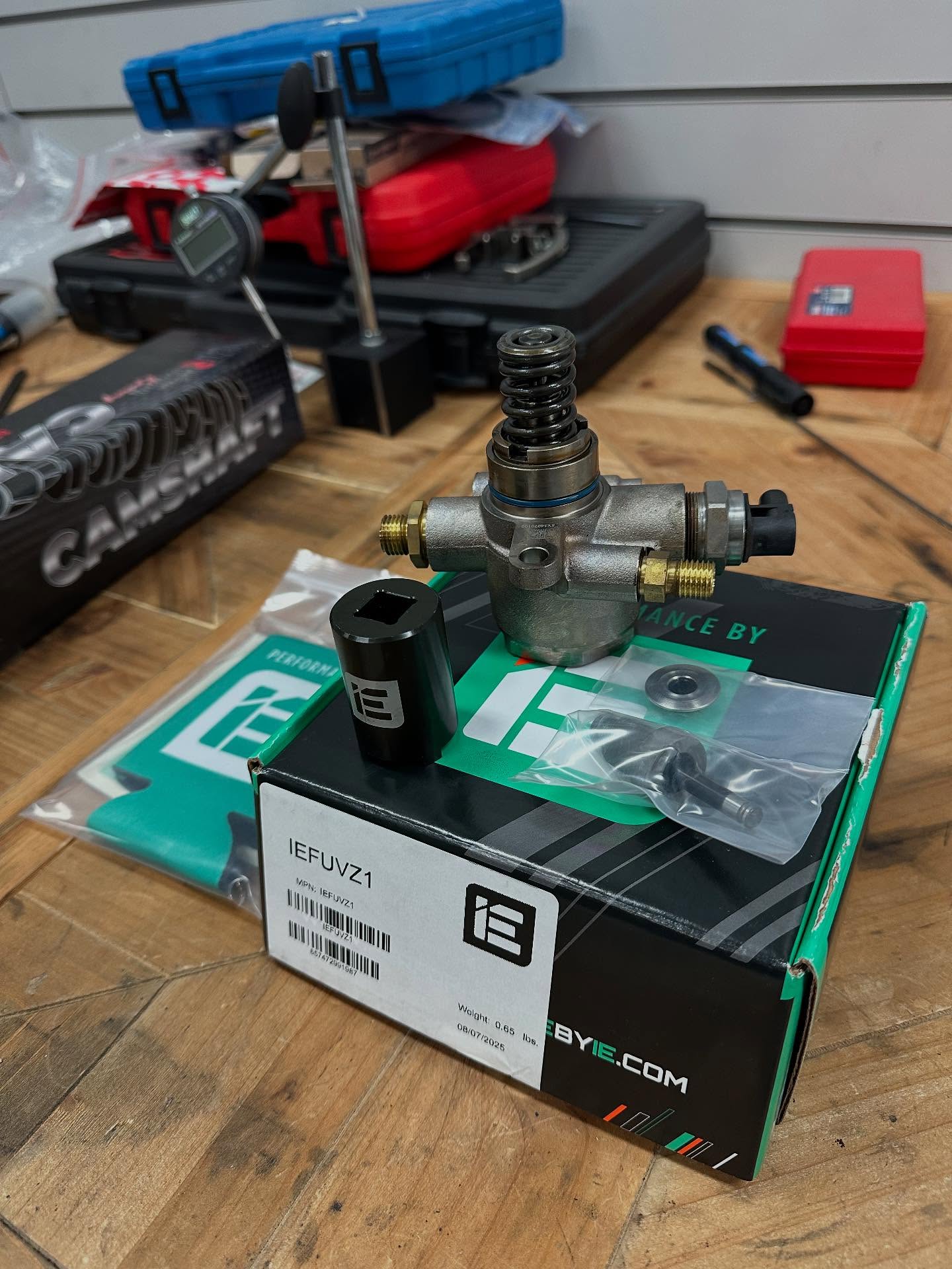 Fuel pump and boxed components on a workshop bench surrounded by tools